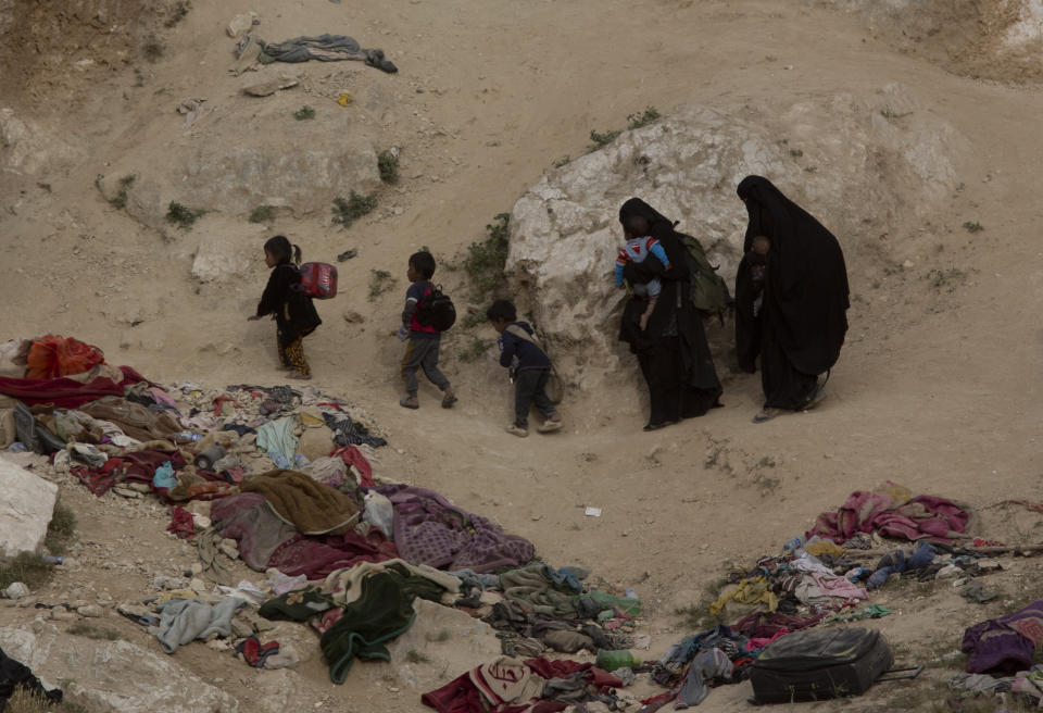 FILE - In this March 14, 2019, file photo, Women and their children who left the besieged Islamic State-held village of Baghouz, Syria, scramble over a rocky hillside to be checked by U.S-backed Syrian Democratic Forces. Some women who travelled across the world to join the Islamic State group’s “caliphate” are pleading to return home, expressing regret and saying they were deceived by the militants’ propaganda. (AP Photo/Maya Alleruzzo, File)