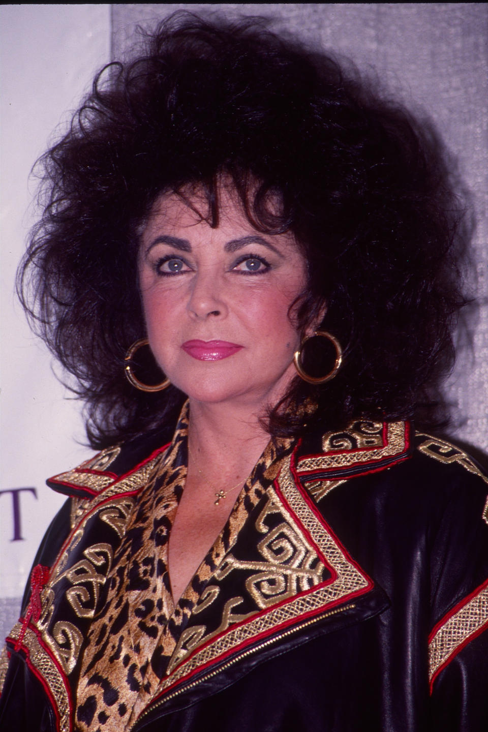 Close-up of Liz wearing a brocade outfit and with big hair