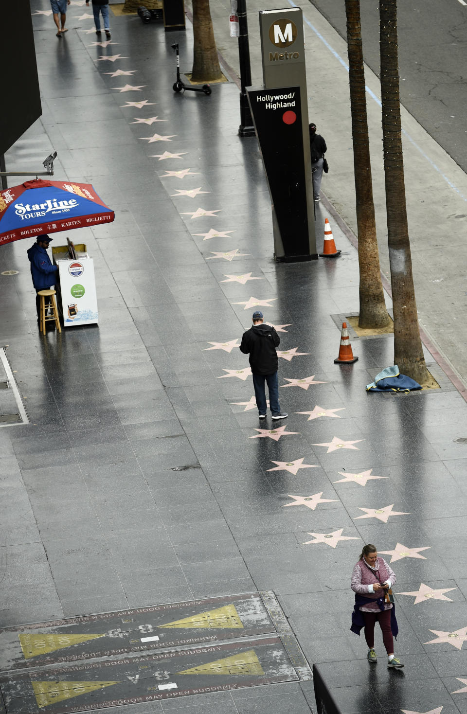Pedestrians walk down a sparsely populated Hollywood Boulevard, Thursday, March 12, 2020, in the Hollywood section of Los Angeles. California Governor Gavin Newsom recommended the cancellation or postponement of gatherings of 250 or more people through at least the end of the month due to the coronavirus outbreak. For most people, the new coronavirus causes only mild or moderate symptoms. For some it can cause more severe illness. (AP Photo/Chris Pizzello)