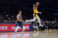 Los Angeles Lakers guard Gabe Vincent, right, intercepts a pass intended for Golden State Warriors guard Stephen Curry during the first half of an NBA basketball game Tuesday, April 9, 2024, in Los Angeles. (AP Photo/Ryan Sun)
