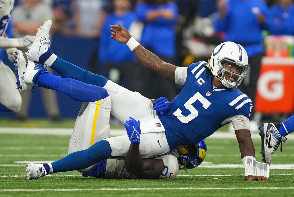 Los Angeles Rams linebacker Byron Young (0) tackles Indianapolis Colts quarterback Anthony Richardson (5) as he gets rid of the ball during the second half of the game Sunday, Oct. 1, 2023, at Lucas Oil Stadium in Indianapolis. The Colts lost in overtime, 29-23.