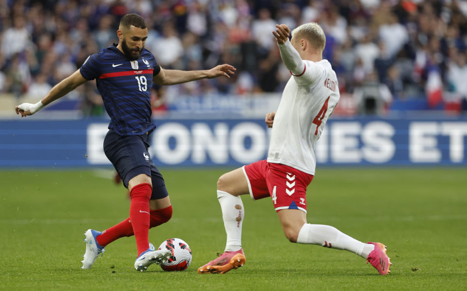 France's Karim Benzema, left, challenges for the ball with Denmark's Victor Nelsson during the UEFA Nations League soccer match between France and Denmark at the Stade de France in Saint Denis near Paris, France, Friday, June 3, 2022. (AP Photo/Jean-Francois Badias)