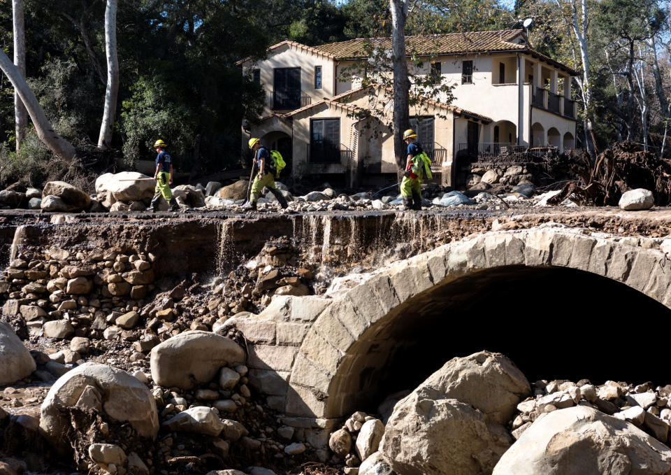 <p>Montecito firefighters walk on a road damaged by mudslides in Montecito, Calif., Jan. 10, 2018. (Photo: Kenneth Song/Santa Barbara News-Press via Reuters) </p>