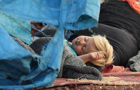 A displaced Syrian child sleeps on a mat laid out on the floor in an olive grove in the town of Atmeh, Idlib province, Syria May 19, 2019. Picture taken May 19, 2019. REUTERS/Khalil Ashawi TPX IMAGES OF THE DAY