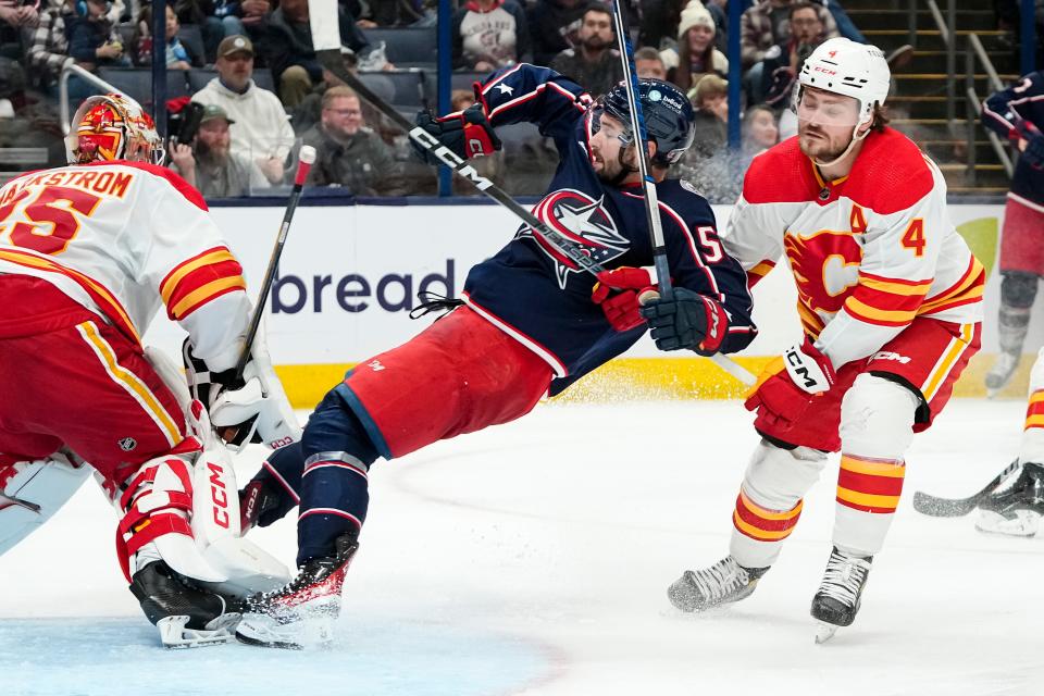 Oct 20, 2023; Columbus, Ohio, USA; Columbus Blue Jackets right wing Emil Bemstrom (52) gets hit into Calgary Flames goaltender Jacob Markstrom (25) by defenseman Rasmus Andersson (4) during the third period of the NHL hockey game at Nationwide Arena. The Blue Jackets on 3-1.