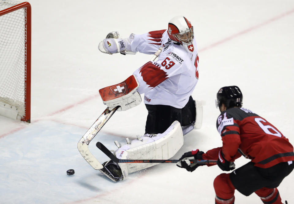 Canada's Mark Stone, right, scores his side's third goal past Switzerland's goalkeeper Leonardo Genoni during the Ice Hockey World Championships quarterfinal match between Canada and Switzerland at the Steel Arena in Kosice, Slovakia, Thursday, May 23, 2019. (AP Photo/Petr David Josek)