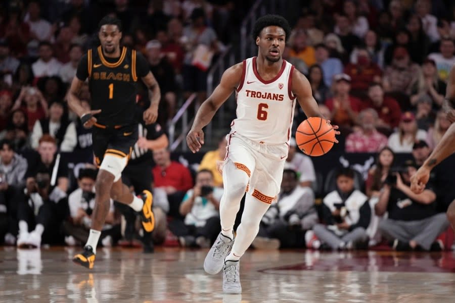 Southern California guard Bronny James, right, dribbles as Long Beach State forward Amari Stroud follows during the first half of an NCAA college basketball game Sunday, Dec. 10, 2023, in Los Angeles. (AP Photo/Mark J. Terrill)