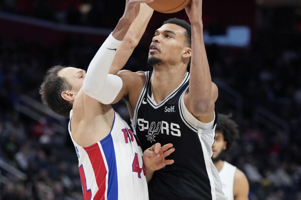 San Antonio Spurs center Victor Wembanyama (1) is defended by Detroit Pistons forward Bojan Bogdanovic (44) during the first half of an NBA basketball game, Wednesday, Jan. 10, 2024, in Detroit. (AP Photo/Carlos Osorio)