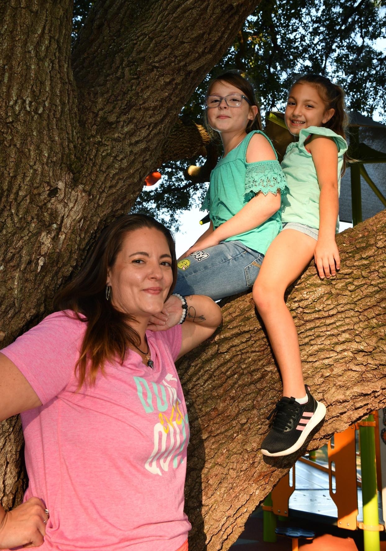 Kayla Yenna, with her daughters, Ashlyn, 11 and Charlotte, 6, who like climbing trees at the Garden of the Five Senses park in North Port. 