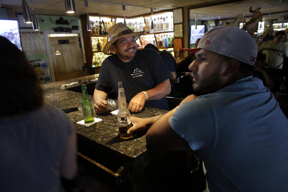In this Thursday, June 27, 2019 photo patrons, who asked that they not be identified by name, are seated in a bar, in Chelsea, Mass. In the last two decades Chelsea and its neighbors Everett, Malden, Revere and Lynn have all become the region's most diverse communities, a Boston Indicators study found. (AP Photo/Steven Senne)