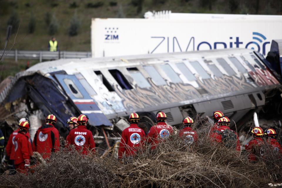 Socorristas maniobran cerca de un vagón descarrilado tras una colisión entre dos trenes en Tempe, a unos 376 kilómetros (235 millas) al norte de Atenas, cerca de la ciudad de Larisa, Grecia, el miércoles 1 de marzo de 2023. (AP Foto/Giannis Papanikos)