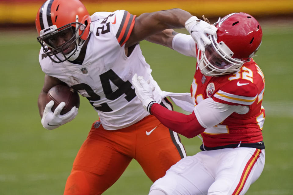 Cleveland Browns running back Nick Chubb (24) is tackled by Kansas City Chiefs safety Tyrann Mathieu (32) during the second half of an NFL divisional round football game, Sunday, Jan. 17, 2021, in Kansas City. (AP Photo/Charlie Riedel)