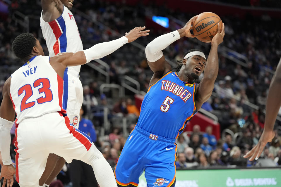 Oklahoma City Thunder guard Luguentz Dort (5) looks to pass as Detroit Pistons guard Jaden Ivey (23) defends during the second half of an NBA basketball game, Sunday, Jan. 28, 2024, in Detroit. (AP Photo/Carlos Osorio)