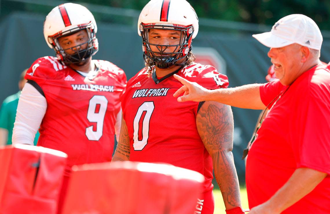 N.C. State defensive end Savion Jackson (9) and defensive tackle Joshua Harris (0) listen to defensive line coach Charley Wiles during the Wolfpack’s first practice of fall camp in Raleigh, N.C., Wednesday, August 3, 2022.