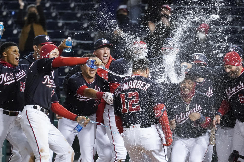 Washington Nationals' Kyle Schwarber (12) celebrates his game-winning home run during the ninth inning of a baseball game against the Arizona Diamondbacks at Nationals Park, Friday, April 16, 2021, in Washington. The Nationals won 1-0. (AP Photo/Alex Brandon)