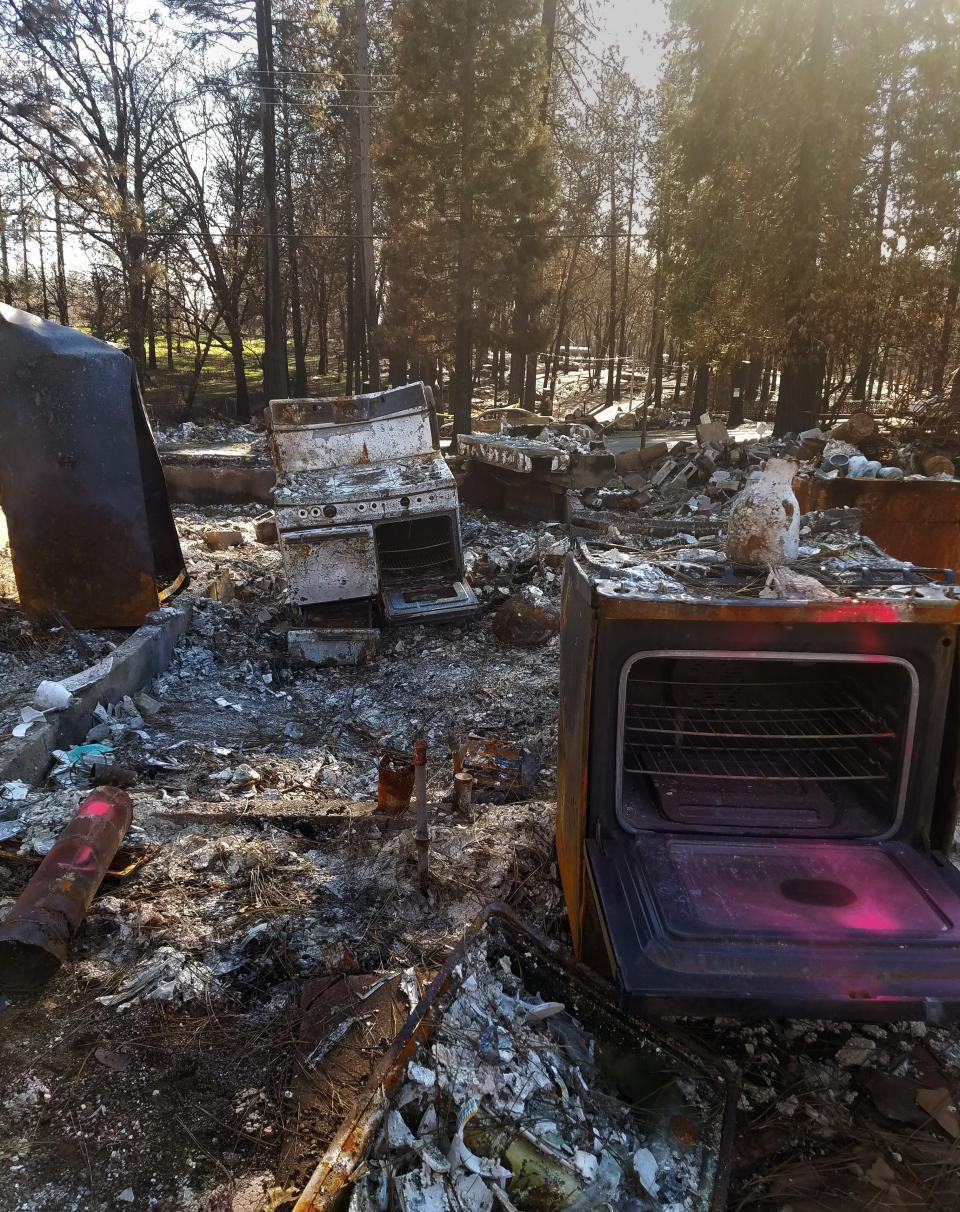 In this January 2019 photo, the remains of kitchen appliances stand in the ashen remains of the Holden family home, which was lost during a 2018 wildfire, in Paradise, Calif. After fleeing one of the most destructive fires in California, the Holden family wanted to find a place that had not been so severely affected by climate change and chose Vermont. (Sue Womack via AP)