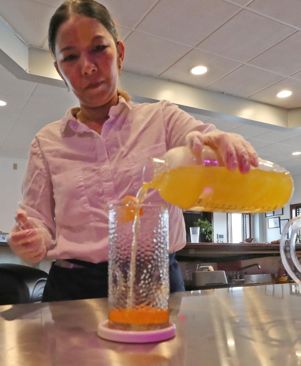 Sajin Lawi, co-owner of Live Mon Thai-Malay restaurant, makes a mango popping boba soda juice at the restaurant on Brittain Road Nov.  29 in Akron.