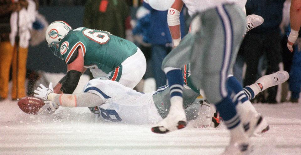 Leon Lett slides into the ball following a blocked field-goal attempt, making the ball live and enabling the Dolphins' Jeff Dellenbach to recover. Pete Stoyanovich then kicked a 19-yard field goal on the final play to give Miami a 16-14 victory.