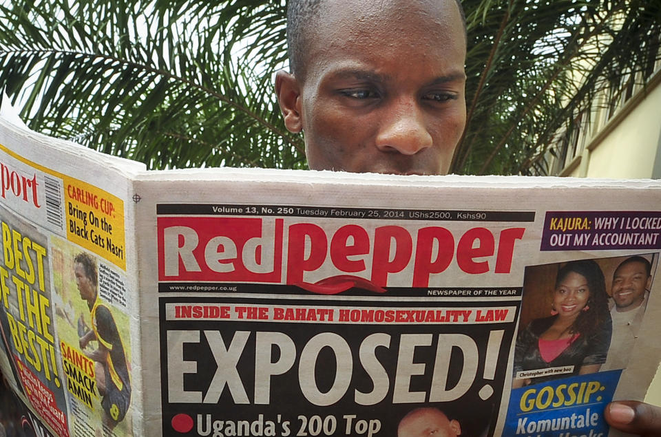 A Ugandan reads a copy of the "Red Pepper" tabloid newspaper in Kampala, Uganda Tuesday, Feb. 25, 2014. The Ugandan newspaper published a list Tuesday of what it called the country's "200 top" homosexuals, outing some Ugandans who previously had not identified themselves as gay, one day after the president Yoweri Museveni enacted a harsh anti-gay law. (AP Photo/Stephen Wandera)