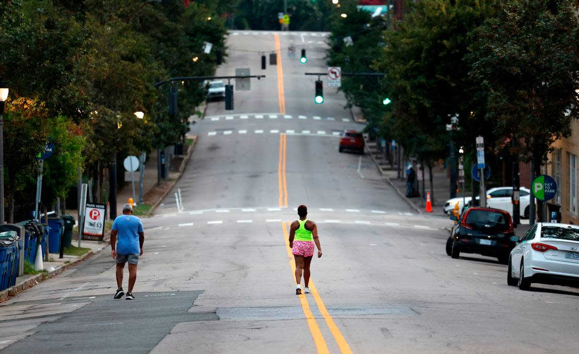 At 6:22 a.m. Saturday, July 22, 2023, walkers head up Glenwood Avenue in the Glenwood South neighborhood of Raleigh, N.C.