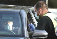 Health care professionals administer the COVID-19 vaccine at Lake-Sumter State College in Leesburg, Fla., on Friday, Jan. 1, 2021. Long lines of cars were at the site as the Lake County vaccines are currently being given to people who are 65 years and older and front line workers. (Stephen M. Dowell /Orlando Sentinel via AP)