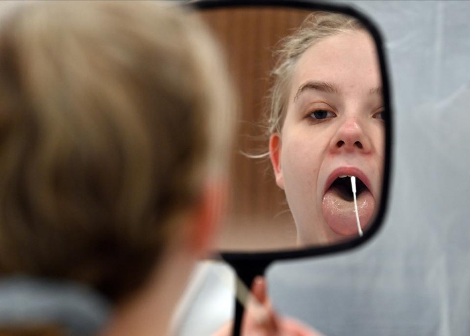 Naomi Carpenter, a 20-year-old  sports rehab student at Hull University, takes a swab for a lateral flow Covid-19 test at the campus sports facilities on January 4, 2021, as students return to the university. - Britain -- one of the worst-affected countries by the global health crisis, with more than 75,000 deaths -- is pinning its hopes on the jab as the mainstay of its mass vaccination drive. (Photo by Paul ELLIS / AFP) (Photo by PAUL ELLIS/AFP via Getty Images)