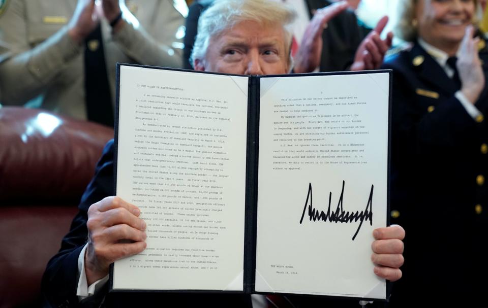 U.S. President Donald Trump holds up his veto of the congressional resolution to end his emergency declaration to get funds to build a border wall after signing it in the Oval Office of the White House in Washington, U.S., March 15, 2019. (Photo: REUTERS/Jonathan Ernst)