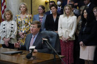 Mississippi Gov. Tate Reeves explains to reporters why he signed the first state bill in the U.S. this year to ban transgender athletes from competing on female sports teams, Thursday, March 11, 2021, at the Capitol in Jackson, Miss. From left standing behind Reeves are Rep. Becky Currie, R-Brookhaven, Rep. Jill Ford, R-Madison, Sen. Jenifer Branning, R-Philadelphia, Sen. Rita Potts Parks, R-Corinth, Rep. Dana McLean, R-Columbus and Sen. Angela Burks Hill, R-Picayune, who were among the legislation's supporters who attended the bill signing. (AP Photo/Rogelio V. Solis)
