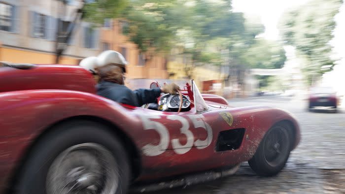 a person racing a red ferrari