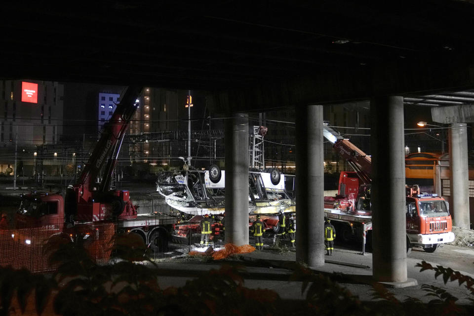 Italian firefighters work at the scene of a passenger bus accident in Mestre, near the city of Venice, Italy, Wednesday, Oct. 4, 2023. The bus fell from an elevated road, late Tuesday, killing multiple people. (AP Photo/Antonio Calanni)