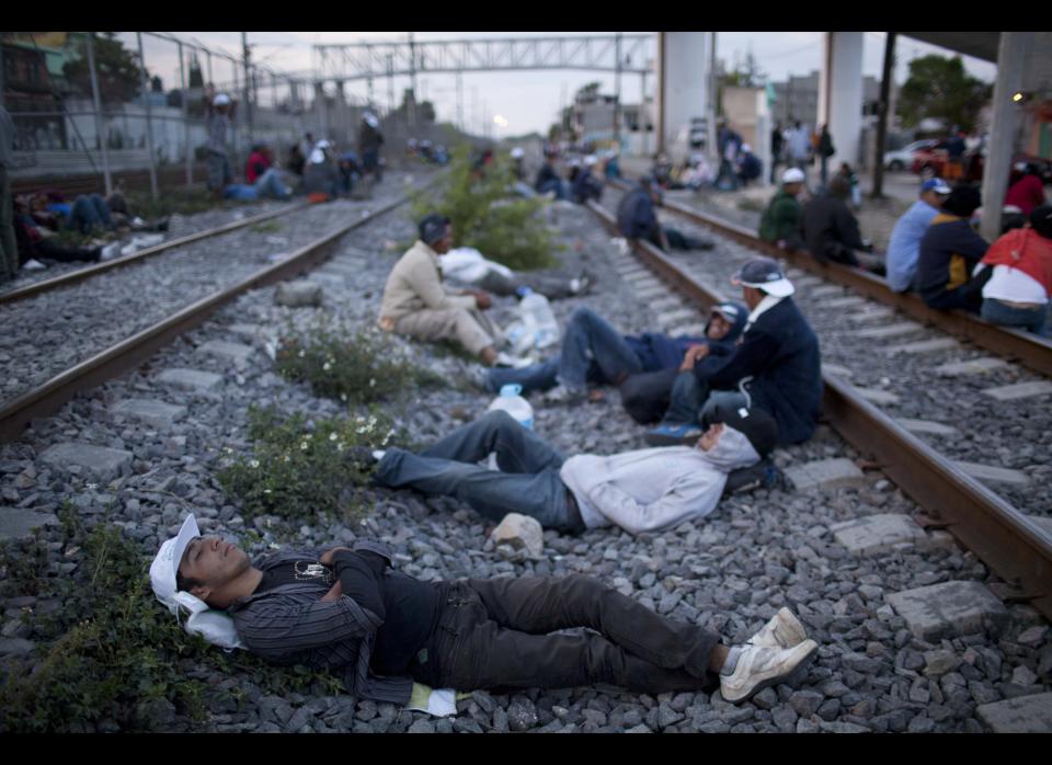 In this May 17, 2012 photo, migrants, mostly from Honduras, rest on railroad tracks as they wait for a train headed north, in Lecheria, on the outskirts of Mexico City. While the number of Mexicans heading to the U.S. has dropped dramatically, a surge of Central American migrants is making the 1,000-mile northbound journey this year, fueled in large part by the rising violence brought by the spread of Mexican drug cartels. (AP Photo/Alexandre Meneghini)