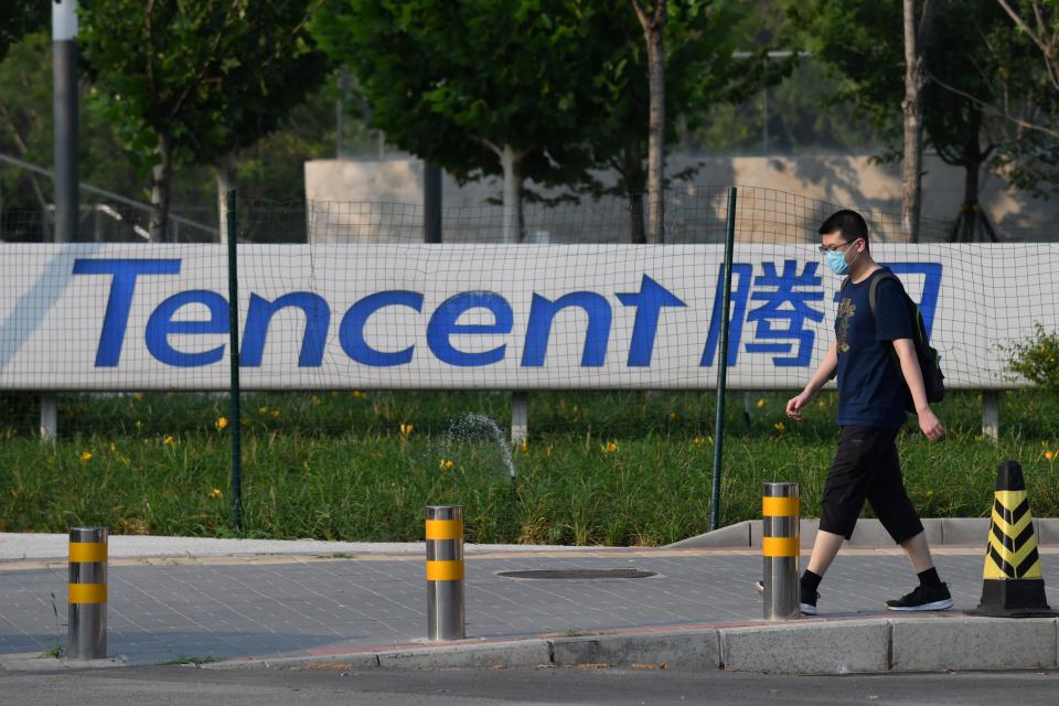 A man walks past a sign for Tencent, the parent company of Chinese social media company WeChat, outside the Tencent headquarters in Beijing on August 7, 2020. - Beijing on August 7 accused the United States of "suppression" after President Donald Trump ordered sweeping restrictions against Chinese social media giants TikTok and WeChat. (Photo by GREG BAKER / AFP) (Photo by GREG BAKER/AFP via Getty Images)