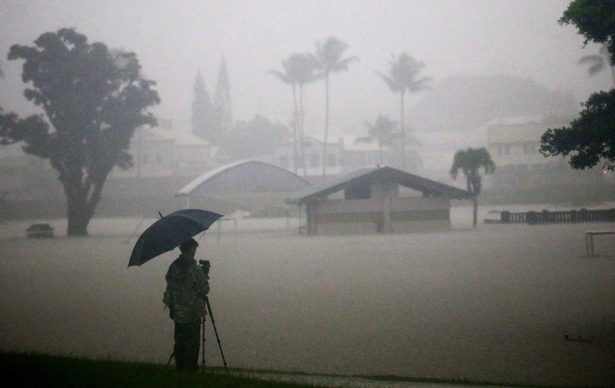 A man takes photos of floodwaters from Hurricane Lane rainfall in Hilo, Hawaii.