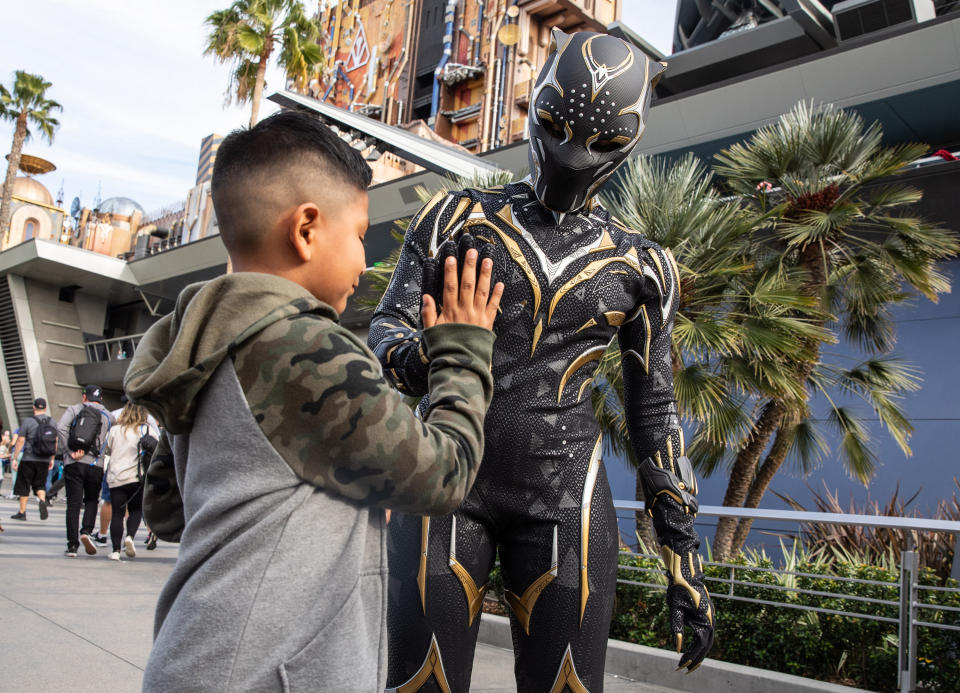 a child high-fiving Black Panther