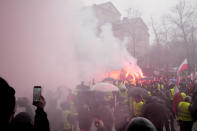 Polish farmers, angry at EU agrarian policy and cheap Ukraine produce imports which, they say, are undercutting their livelihoods, light flares in protest before the office of the regional governor, in Poznan, western Poland, Friday Feb. 9, 2024. (AP Photo/Czarek Sokolowski)