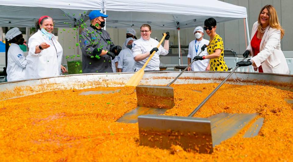 Madeline Pumariega, far-right, and WSVN-7’s Belkys Nerey, next to Pumariega, help culinary students make paella during the Wolfson Campus Investiture Ceremony in downtown Miami, Florida on Wednesday, November 3, 2021. Pumariega is the college’s first female president.