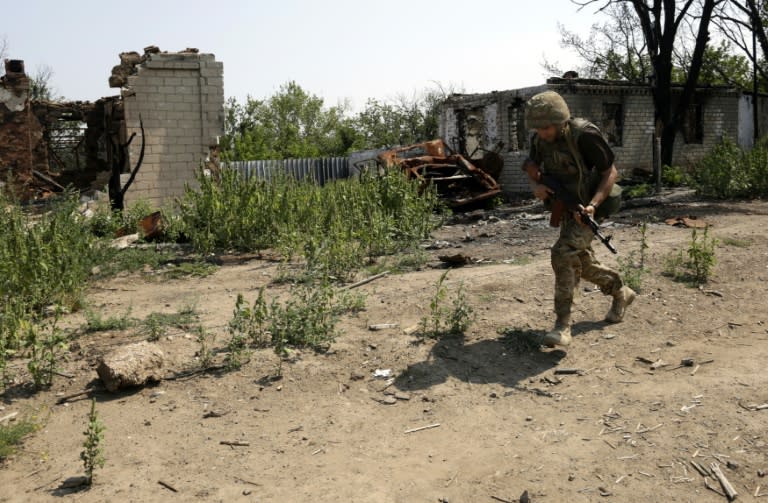 A Ukrainian serviceman runs for cover during clashes with pro-Russian separatists in the village of Luganske, on August 1, 2015