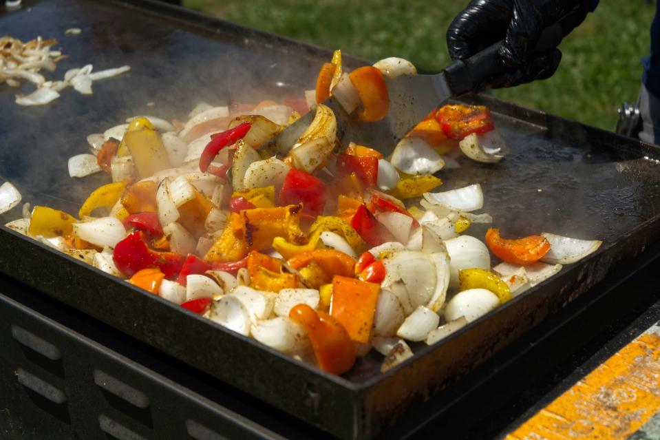 Cooks roasting vegetables at Grace of Christ Slavic Baptist Church's Ukraine fundraiser at Washington Plaza Saturday, April 22, 2023. The event attracted hundreds of attendees and raised money to support the church's ongoing efforts to aid Ukrainian civilians.
