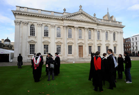 FILE PHOTO: Graduates gather outside Senate House after their graduation ceremony at Cambridge University in eastern England October 23, 2010. REUTERS/Paul Hackett