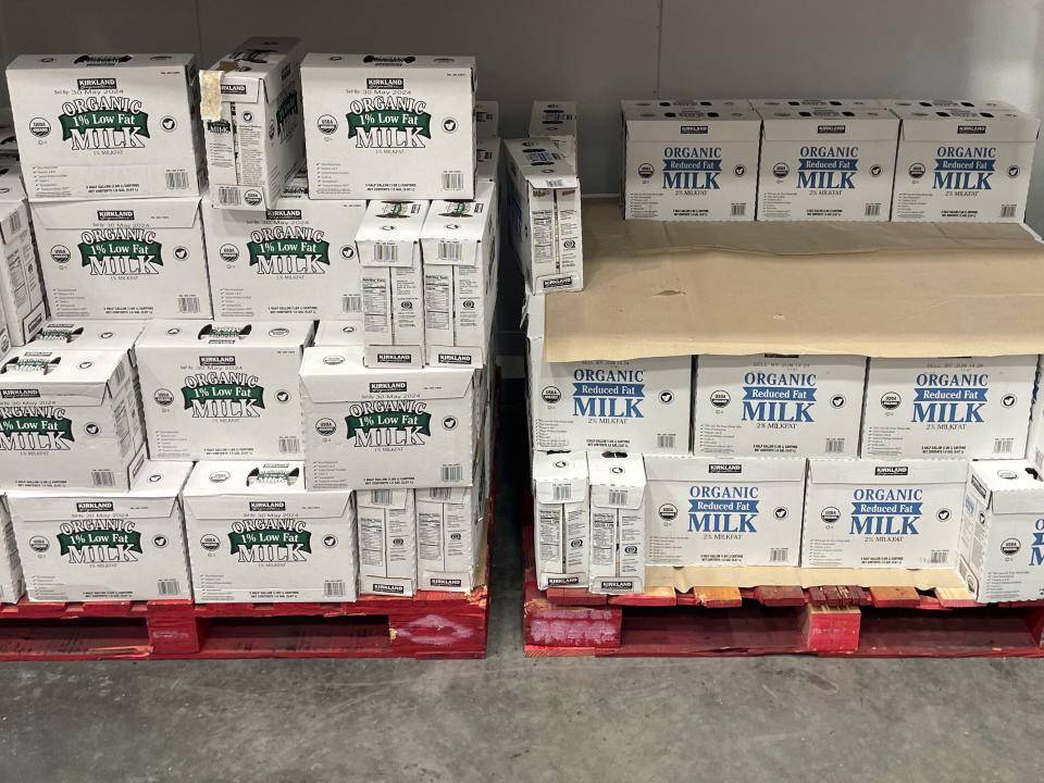 Boxes of low-fat and reduced-fat milk on palates at Costco. Boxes of low-fat milk have green labels and boxes of reduced-fat milk have blue labels