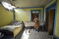 A local woman shows damage in her house after the shelling by Armenian forces in the Tovuz region of Azerbaijan, Tuesday, July 14, 2020. Skirmishes on the volatile Armenia-Azerbaijan border escalated Tuesday, marking the most serious outbreak of hostilities between the neighbors since the fighting in 2016. (AP Photo/Ramil Zeynalov)