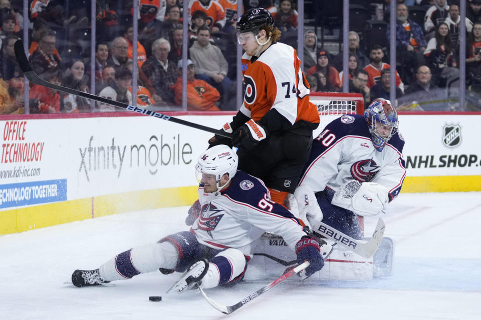 Philadelphia Flyers' Owen Tippett (74) collides with Columbus Blue Jackets' Jack Roslovic (96) and Daniil Tarasov (40) during overtime in an NHL hockey game, Thursday, Jan. 4, 2024, in Philadelphia. (AP Photo/Matt Slocum)