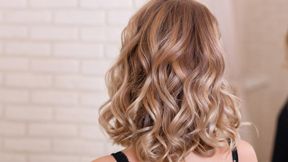 The back of a woman's head of hair that's been curled with a straightener