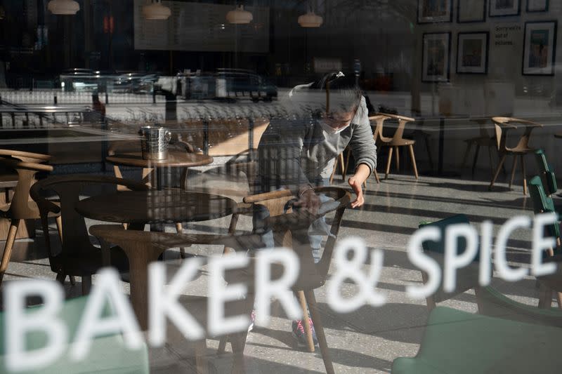 Staff member wipes a chair inside a Baker and Spice restaurant in Beijing