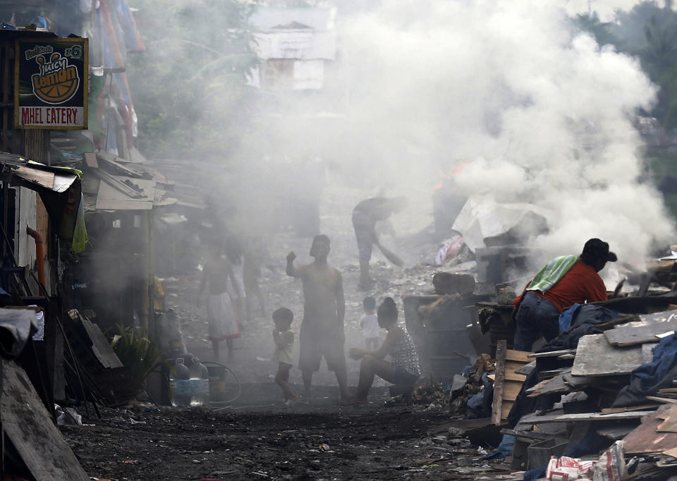 <p>Filipinos burn wood at a makeshift charcoal factory in Taguig, south of Manila, on May 24, 2016. According to a United Nations Environment Program report, the Asia-Pacific region is the world’s most disaster-prone. (Francis R. Malasig/EPA) </p>