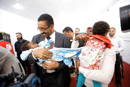 Members of Libyan Red Crescent hand over the children of Sudanese Islamic State members who operated in Libya, to a Sudanese official, in Misrata, Libya August 20, 2017. REUTERS/Ismail Zitouny