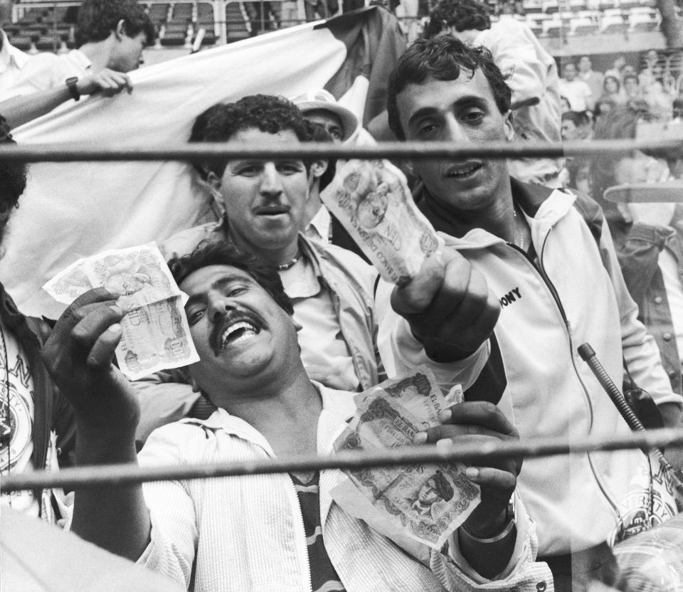 FILE - Algerian soccer supporters show money to photographers in protest, in Gijon, Spain, after the World Cup soccer match between West Germany and Austria on June 25, 1982. West Germany were leading Austria 1-0 after 10 minutes of play, then both teams pointlessly kicked the ball around, barely breaking a sweat and ensuring they both qualified at Algeria's expense. (AP Photo/File)