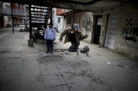 Un niño juega con una pelota de fútbol afuera de un complejo de apartamentos en el barrio de Fuerte Apache, donde creció el astro Carlos Tevez, en Buenos Aires, Argentina, el lunes 15 de junio de 2020. (AP Foto/Natacha Pisarenko)