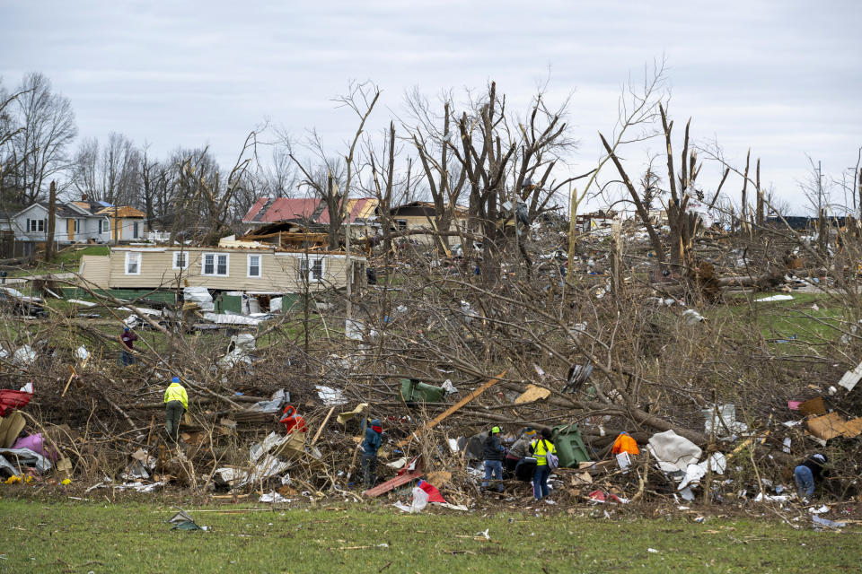 Volunteers comb through an area that was heavily damage by a tornado in Sullivan, Ind., Saturday, April 1, 2023, as search-and-rescue efforts continue. Storms that spawned possibly dozens of tornadoes have killed several people in the South and Midwest. (AP Photo/Doug McSchooler)