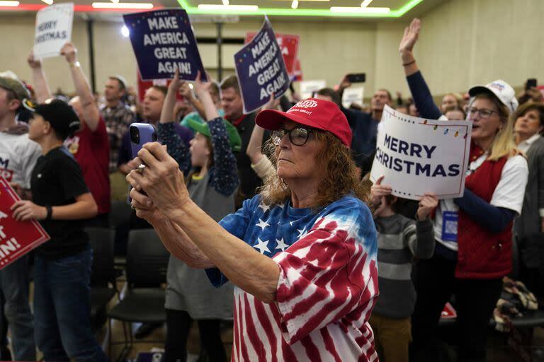 Miembros del público reaccionan mientras el ex presidente Donald Trump habla durante un mitin, el martes 19 de diciembre de 2023, en Waterloo, Iowa.